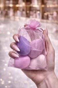 Hand holding the organza pouch containing four makeup blender sponges