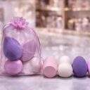 Four teardrop makeup blender sponges in pink, cream and lilac with an organza pouch
