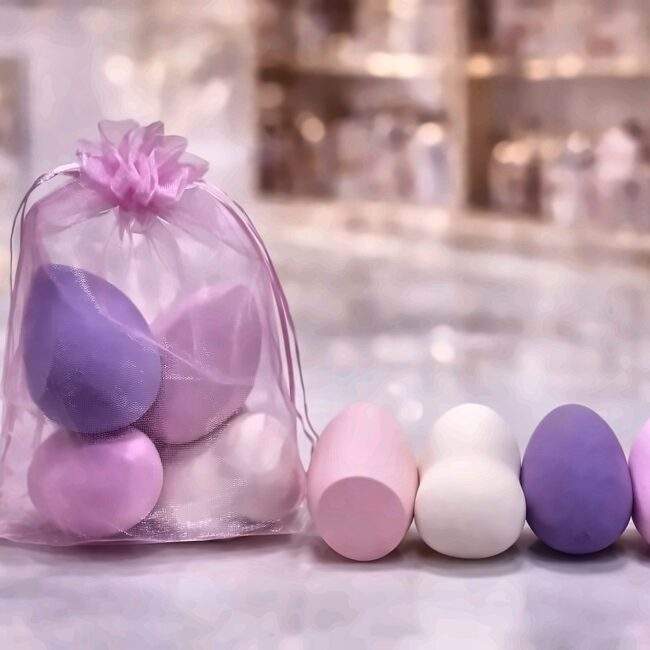 Four teardrop makeup blender sponges in pink, cream and lilac with an organza pouch